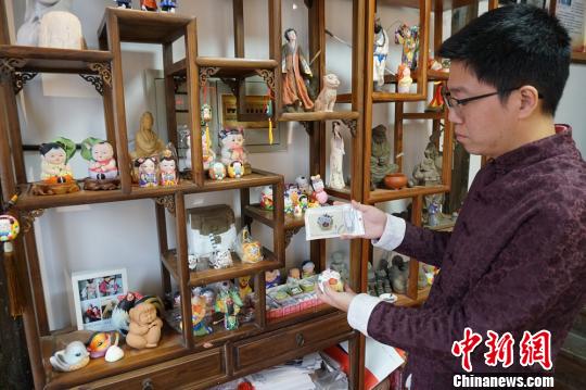 图为倪俊展示以“惠山泥人”为原型制作的充电宝。　孙权 摄